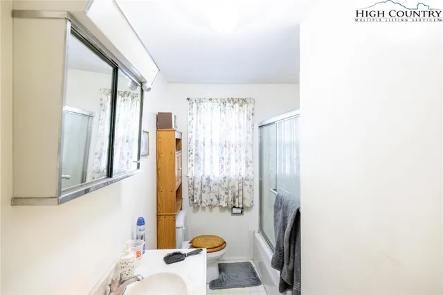 a bathroom with a sink a toilet and shower curtain