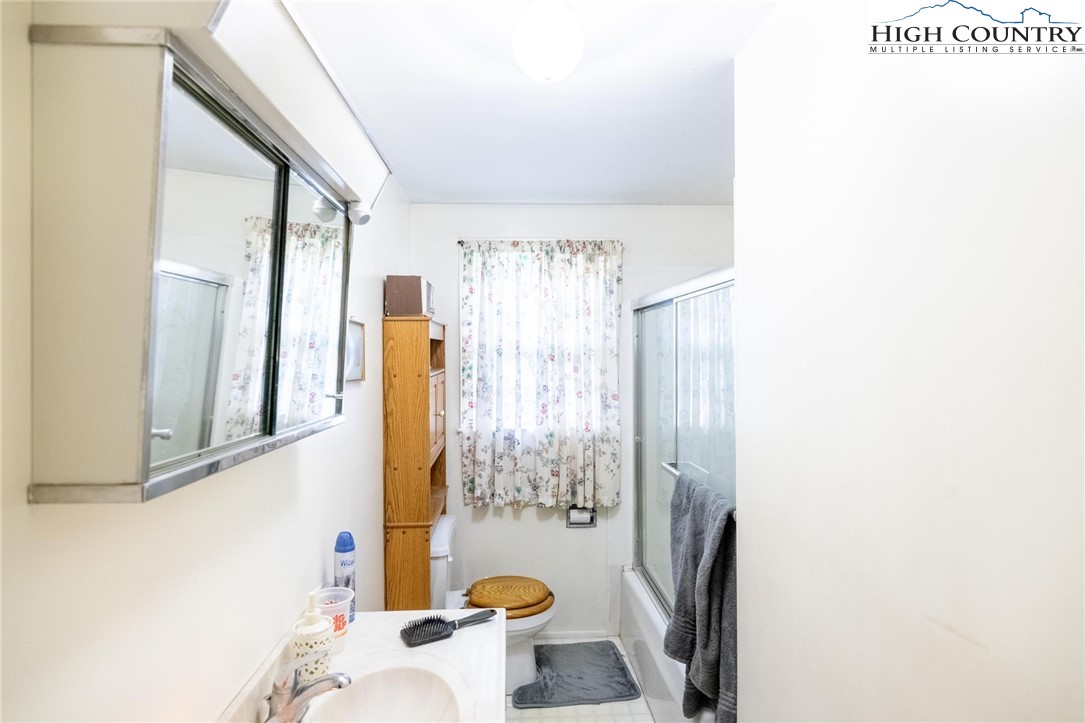 4690 3 Top Road Todd, NC 28684 - Photo 19 of 49 a bathroom with a sink a toilet and shower curtain