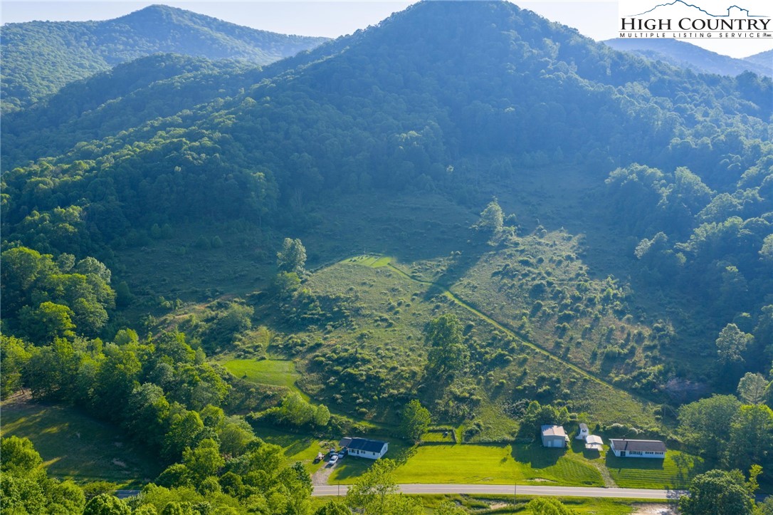 4690 3 Top Road Todd, NC 28684 - Photo 23 of 49 a view of a lush green hillside and a houses