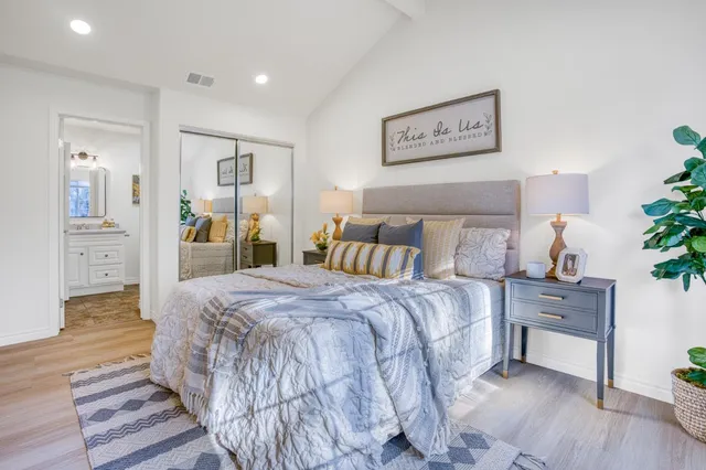 a spacious bedroom with a bed and wooden floor