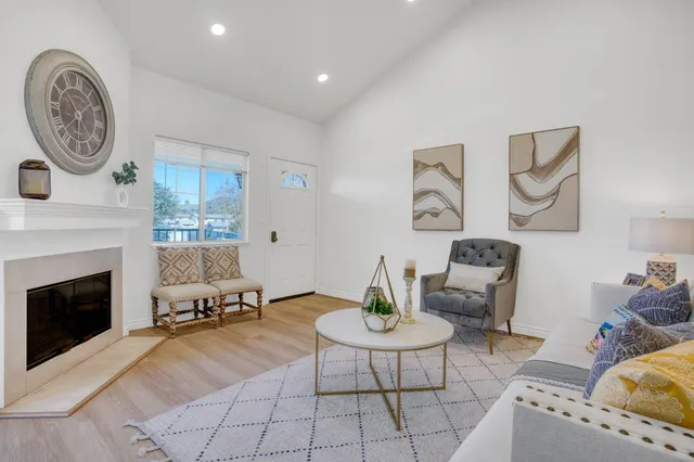 a living room with furniture a clock and a fireplace