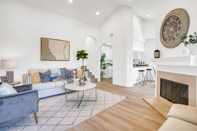a living room with furniture a clock and a fireplace