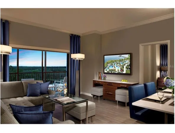 a living room with furniture a flat screen tv and a floor to ceiling window