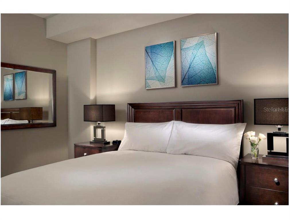 14501 Grove Resort Avenue, Unit 1237 Winter Garden, FL 34787 - Photo 6 of 7 a bedroom with a bed and a tv