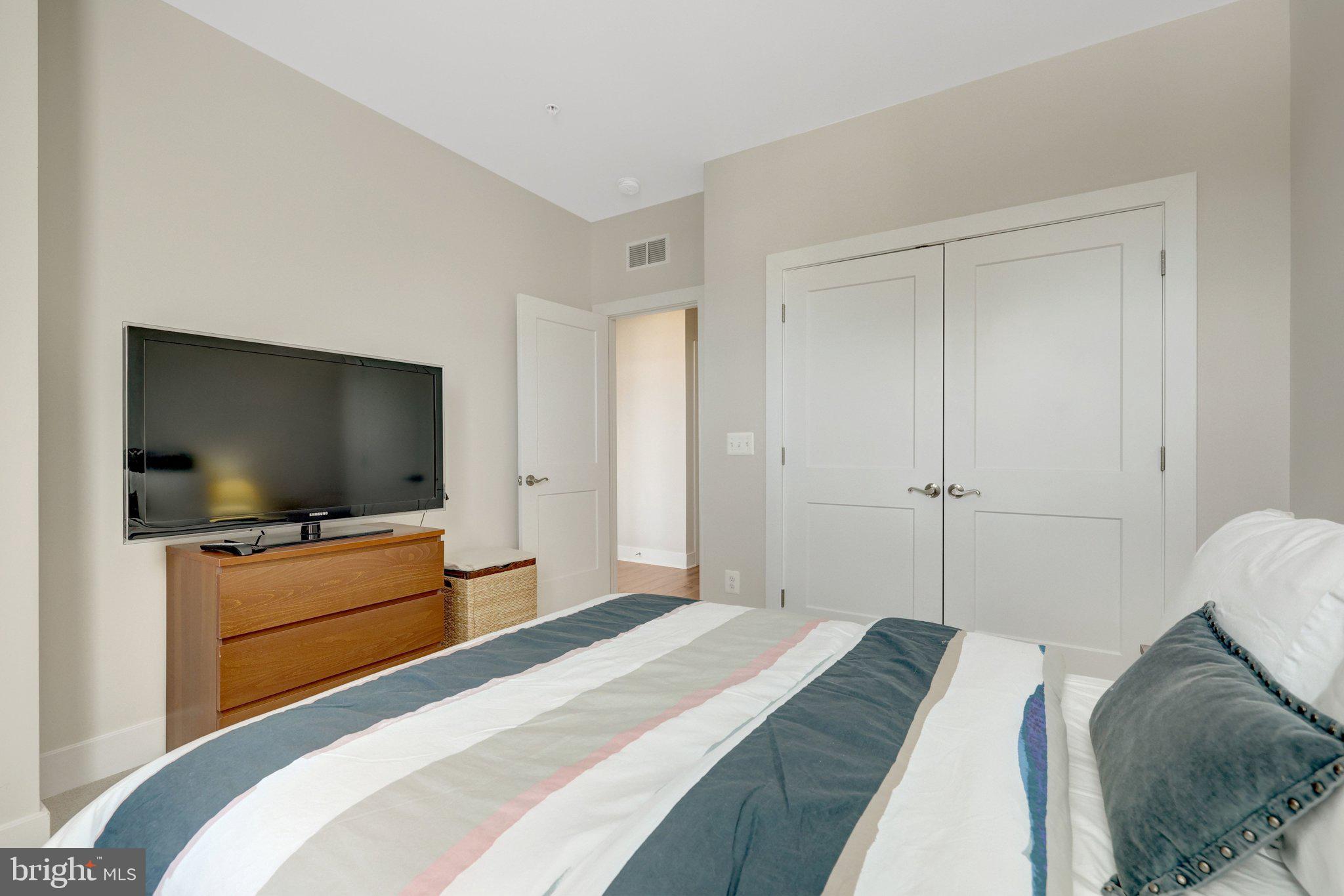1694 Bandit Loop, Unit 17B Reston, VA 20190 - Photo 30 of 46 a bedroom with a bed and a flat screen tv