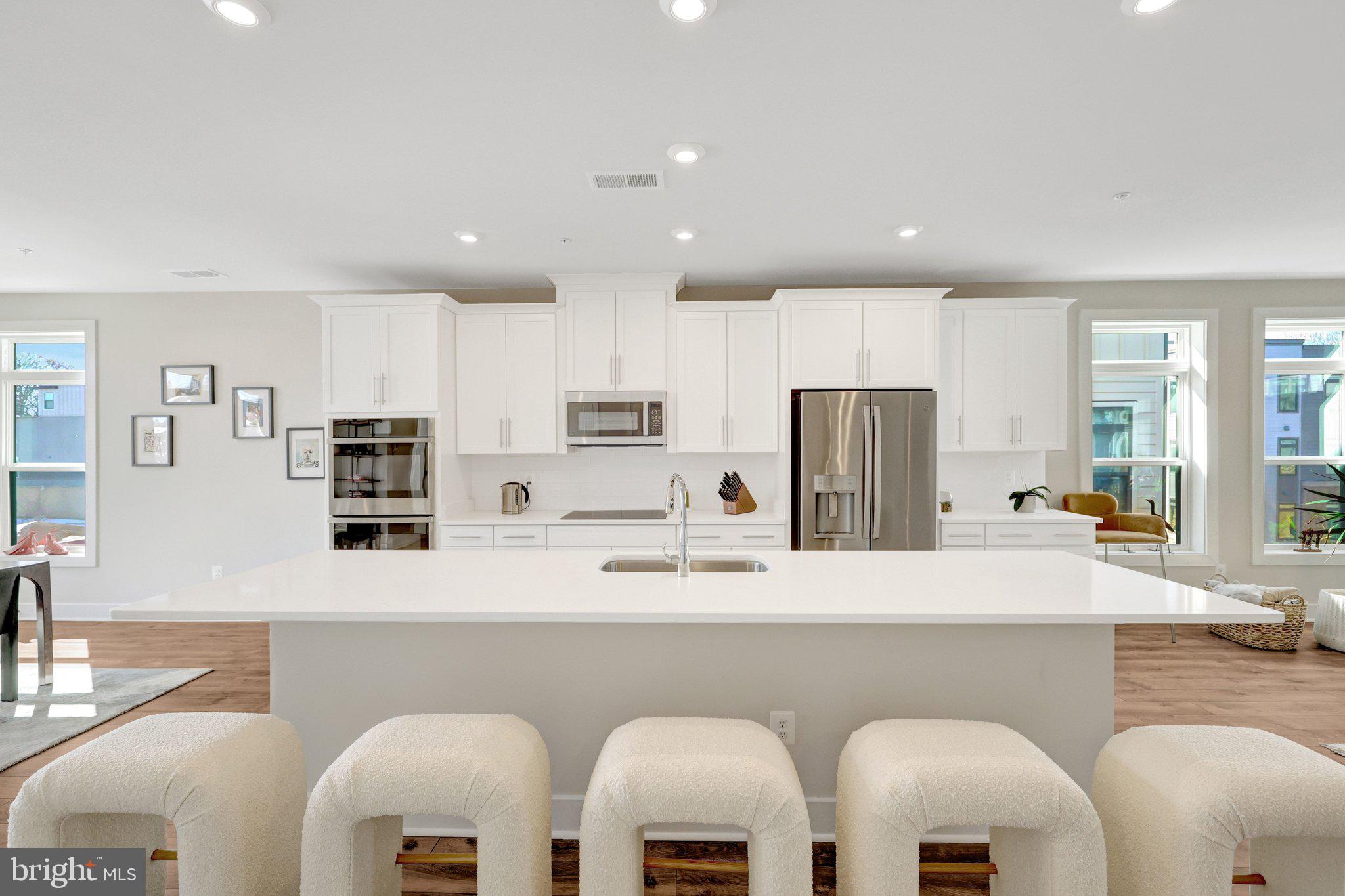 1694 Bandit Loop, Unit 17B Reston, VA 20190 - Photo 3 of 46 a kitchen with stainless steel appliances granite countertop a table chairs sink refrigerator and microwave