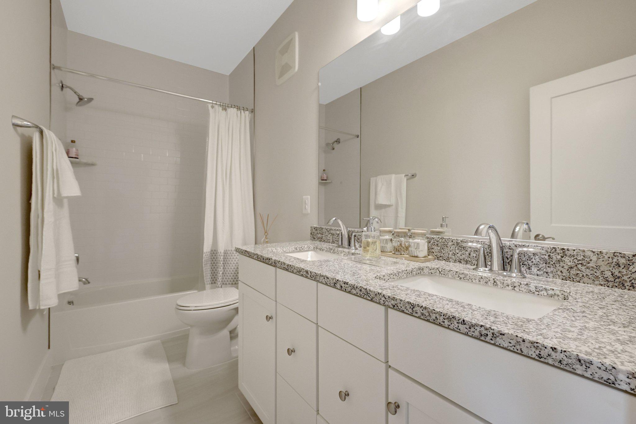 1694 Bandit Loop, Unit 17B Reston, VA 20190 - Photo 33 of 46 a bathroom with a granite countertop sink toilet and shower