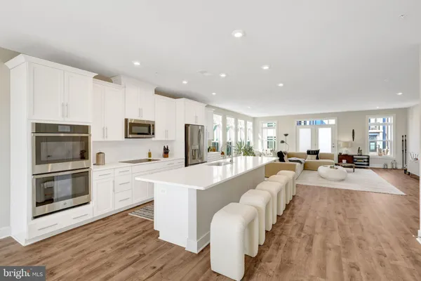a large white kitchen with stainless steel appliances