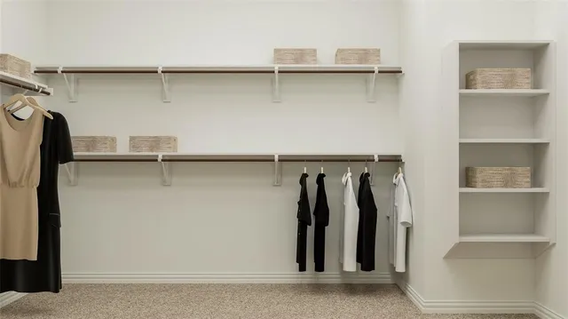 a view of walk in closet with clothes and shoes