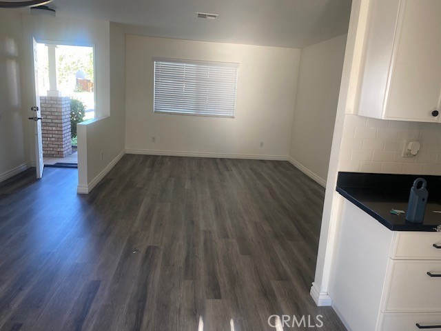 15177 Braxton Street Adelanto, CA 92301 - Photo 3 of 34 an empty room with wooden floor and windows