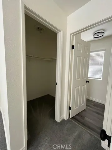 a view of a hallway with wooden floor and closet area