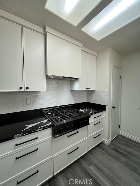 15177 Braxton Street Adelanto, CA 92301 - Photo 10 of 34 a kitchen with granite countertop white cabinets and black stove top oven with wooden floor