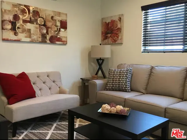 a living room with furniture a couch and a window
