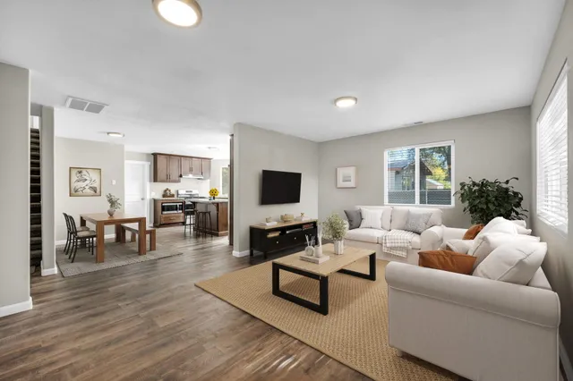 a living room with furniture wooden floor and a flat screen tv