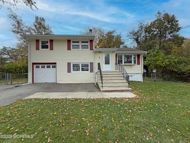 a front view of a house with a yard and trees