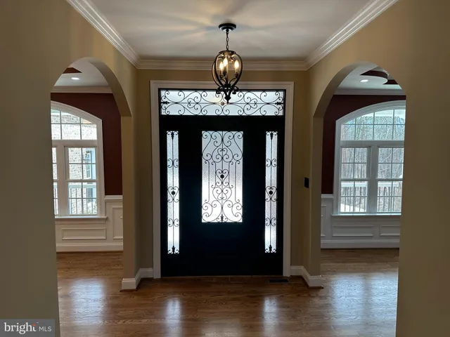 a view of an entryway with wooden floor door and windows