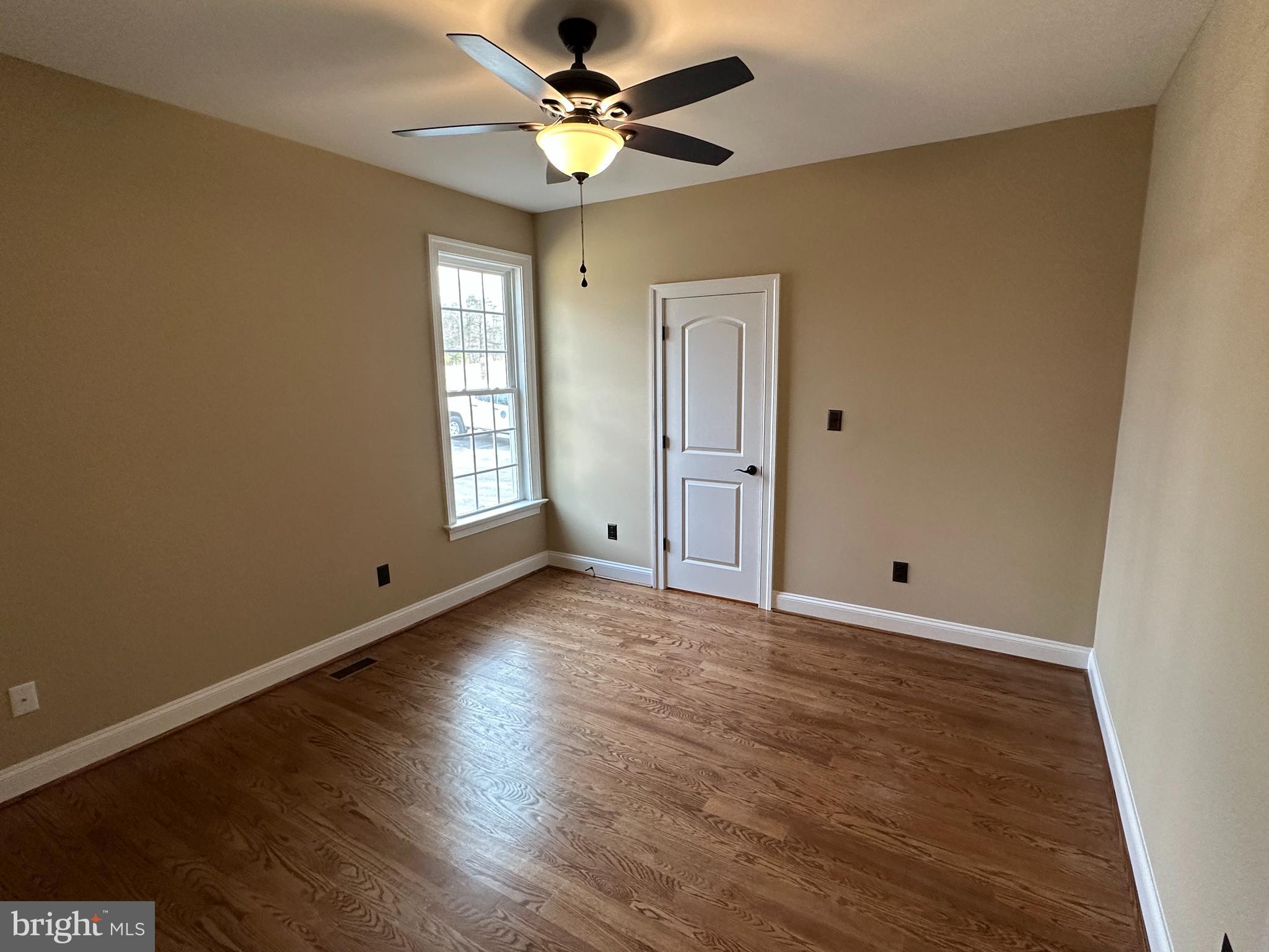 2225 Cedar Grove Road Winchester, VA 22603 - Photo 36 of 48 an empty room with wooden floor ceiling fan and windows