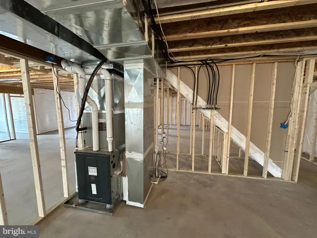 a view of an empty room with wooden floor and stairs