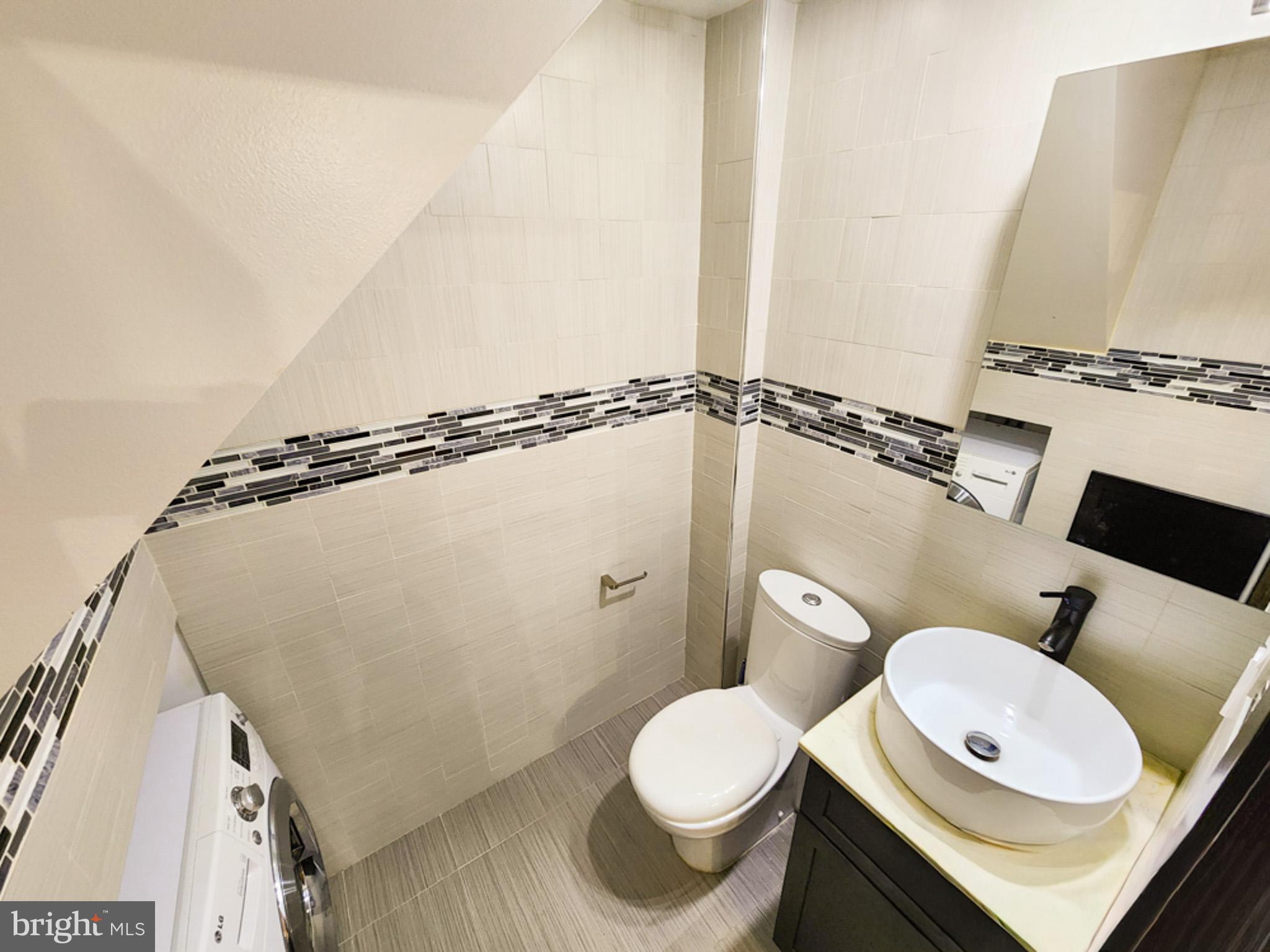 12135 Academy Road, Unit 77 Philadelphia, PA 19154 - Photo 4 of 12 a bathroom with a sink a toilet and a mirror