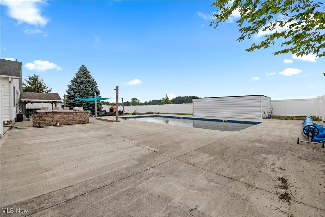 47147 Merriam Road Wellington, OH 44090 - Photo 45 of 49 View of swimming pool featuring a patio area, a fenced backyard, and an outdoor storage structure