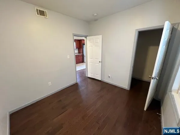 an empty room with wooden floor and entrance