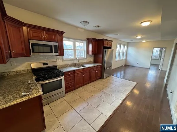 a large kitchen with stainless steel appliances granite countertop a stove a sink and a microwave