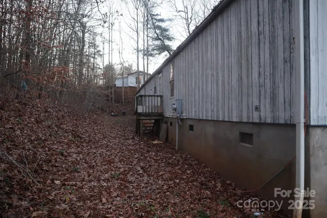 a view of backyard with wooden fence and large trees