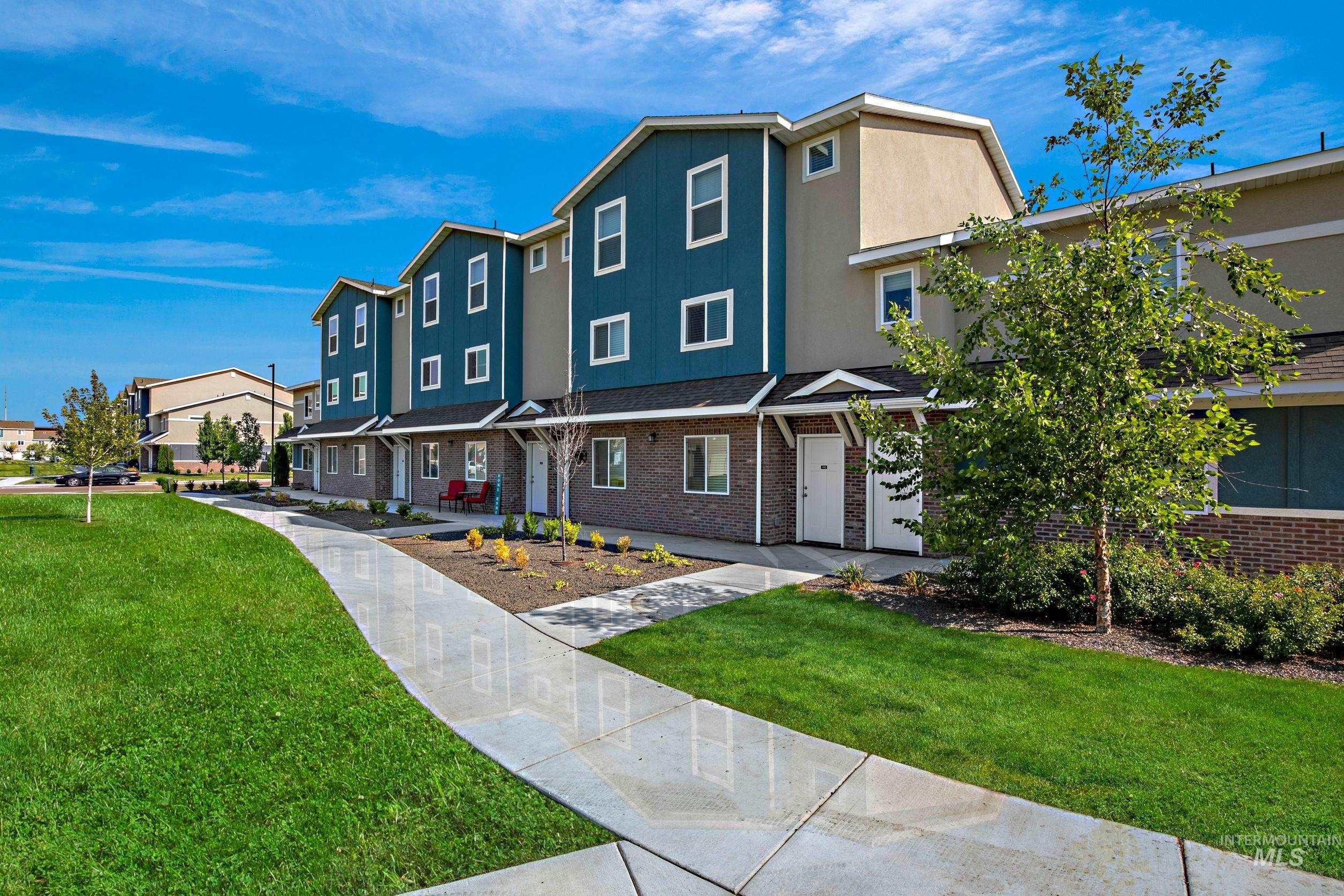 View of front of house with stucco siding, a residential view, a front lawn, and brick siding