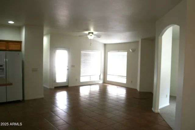 a view of an empty room with glass door and wooden floor