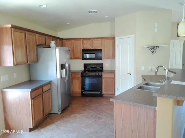 a kitchen with stainless steel appliances granite countertop a refrigerator and a stove top oven