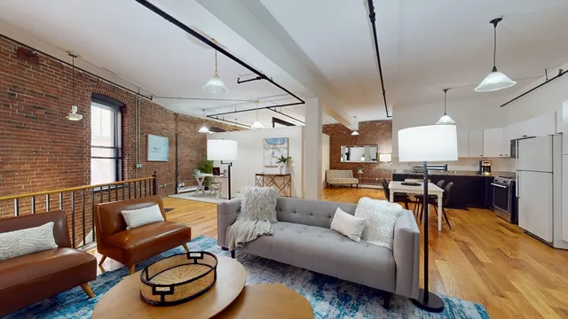 a living room with furniture a rug and kitchen view