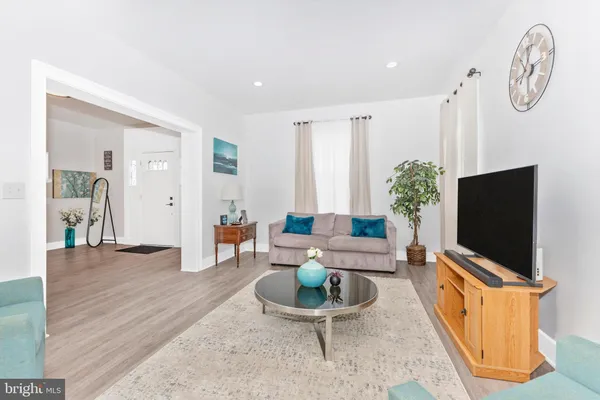 a living room with furniture a flat screen tv and a large window