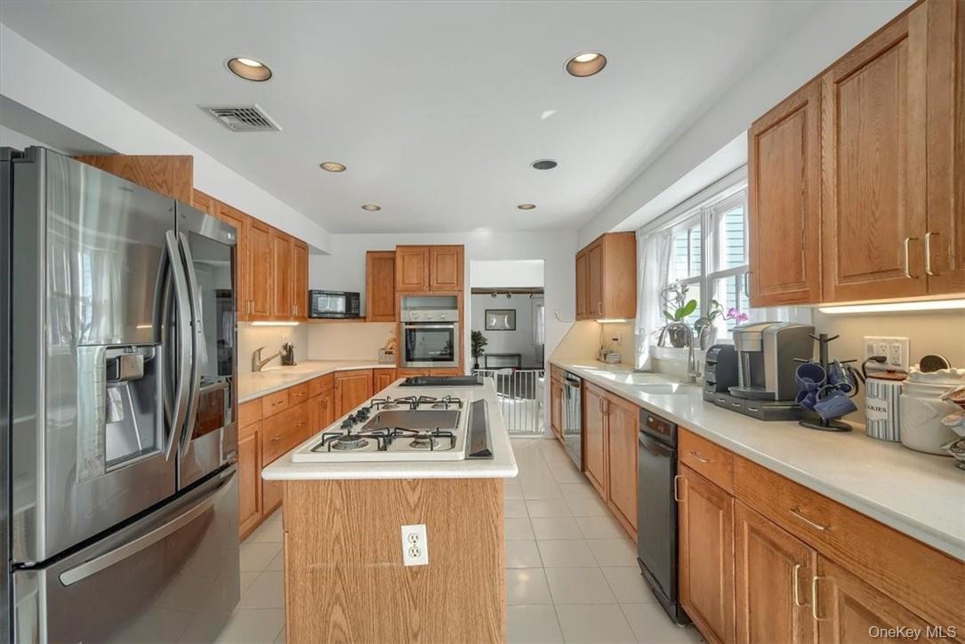 10 High Tor Road New City, NY 10956 - Photo 10 of 33 a kitchen with stainless steel appliances granite countertop a refrigerator a sink dishwasher a stove and white countertops with wooden floor