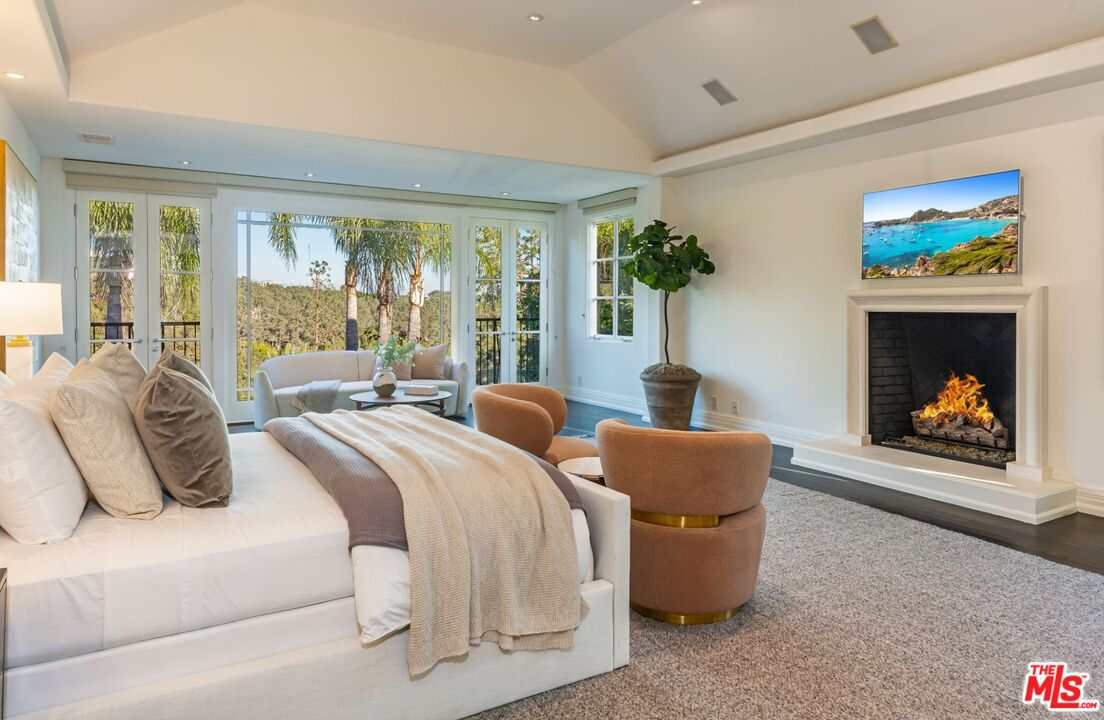 8 Oakmont Drive Los Angeles, CA 90049 - Photo 26 of 46 a living room with furniture a fireplace and a floor to ceiling window