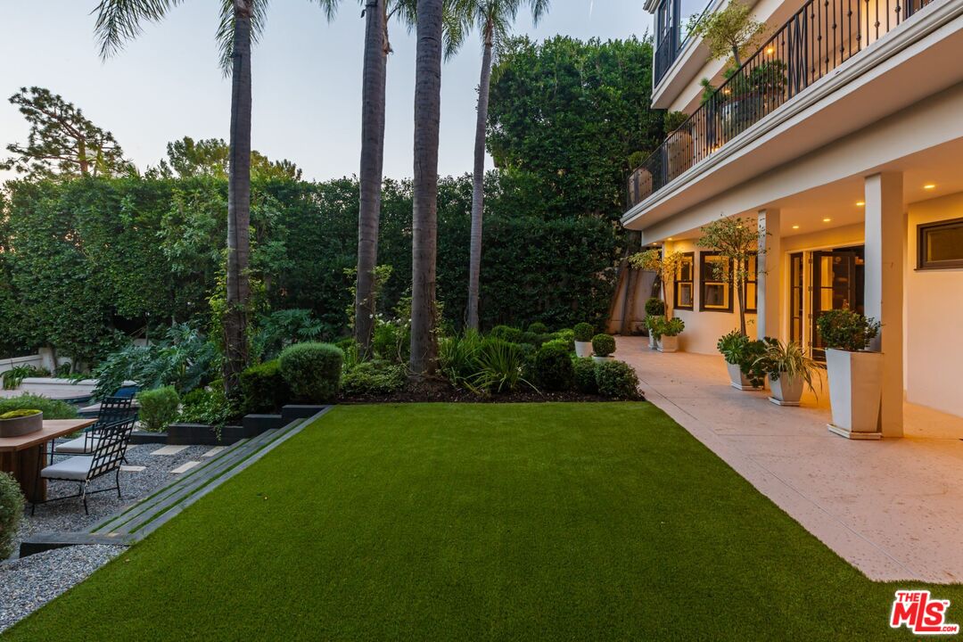 8 Oakmont Drive Los Angeles, CA 90049 - Photo 33 of 46 a view of a patio with table and chairs potted plants and palm trees