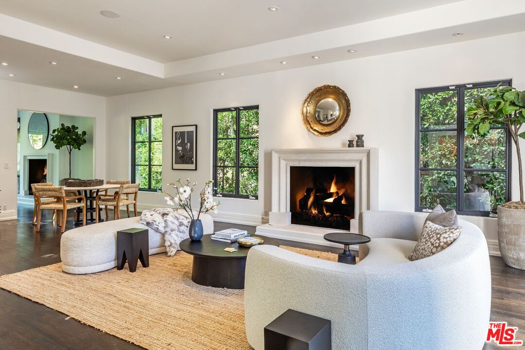 8 Oakmont Drive Los Angeles, CA 90049 - Photo 6 of 46 a living room with furniture a fireplace and a floor to ceiling window