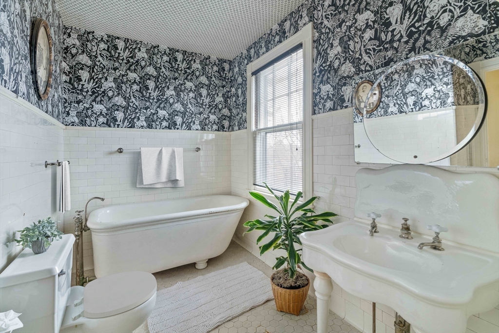 285 Clinton Road Brookline, MA 02245 - Photo 19 of 28 a bath room with a toilet a sink and a mirror