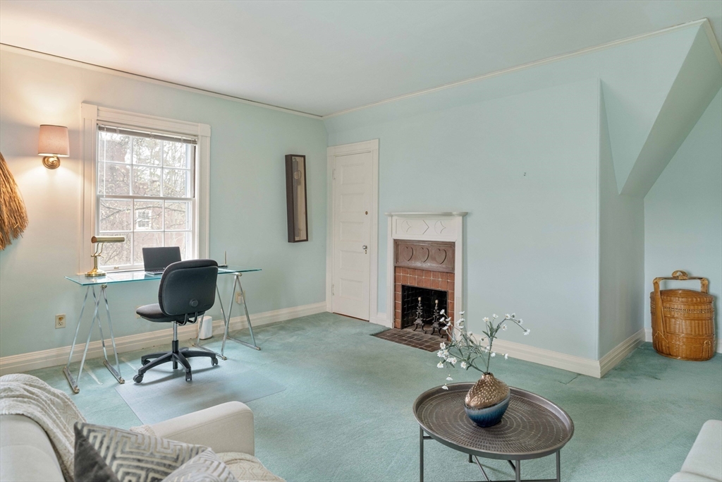 285 Clinton Road Brookline, MA 02245 - Photo 26 of 28 a living room with furniture a fireplace and a large window