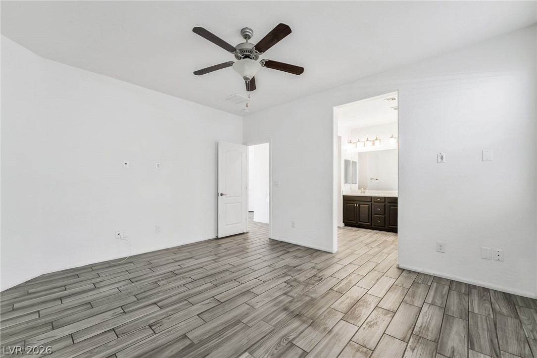 6245 Andover Wood Road Las Vegas, NV 89113 - Photo 19 of 37 A restful bedroom offers wood-look tile flooring and a ceiling fan for comfort.
