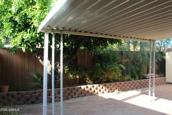 a patio with glass top table and chairs