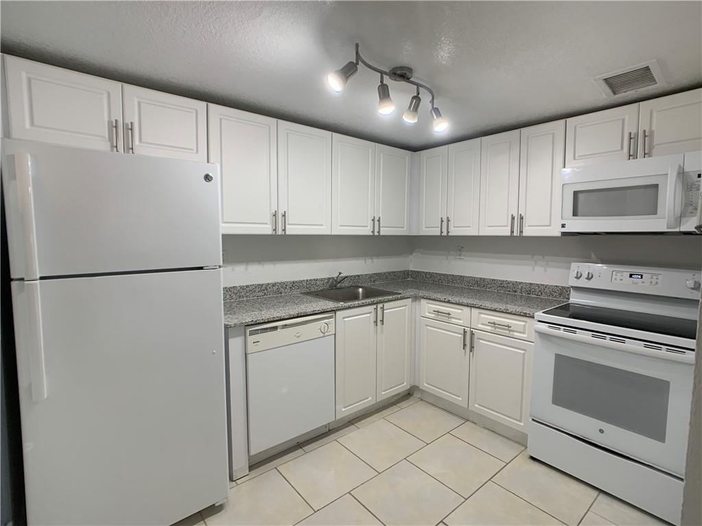 9357 Southwest 77th Avenue, Unit 25245 Miami, FL 33156 - Photo 1 of 20 a kitchen with granite countertop cabinets stainless steel appliances and a sink