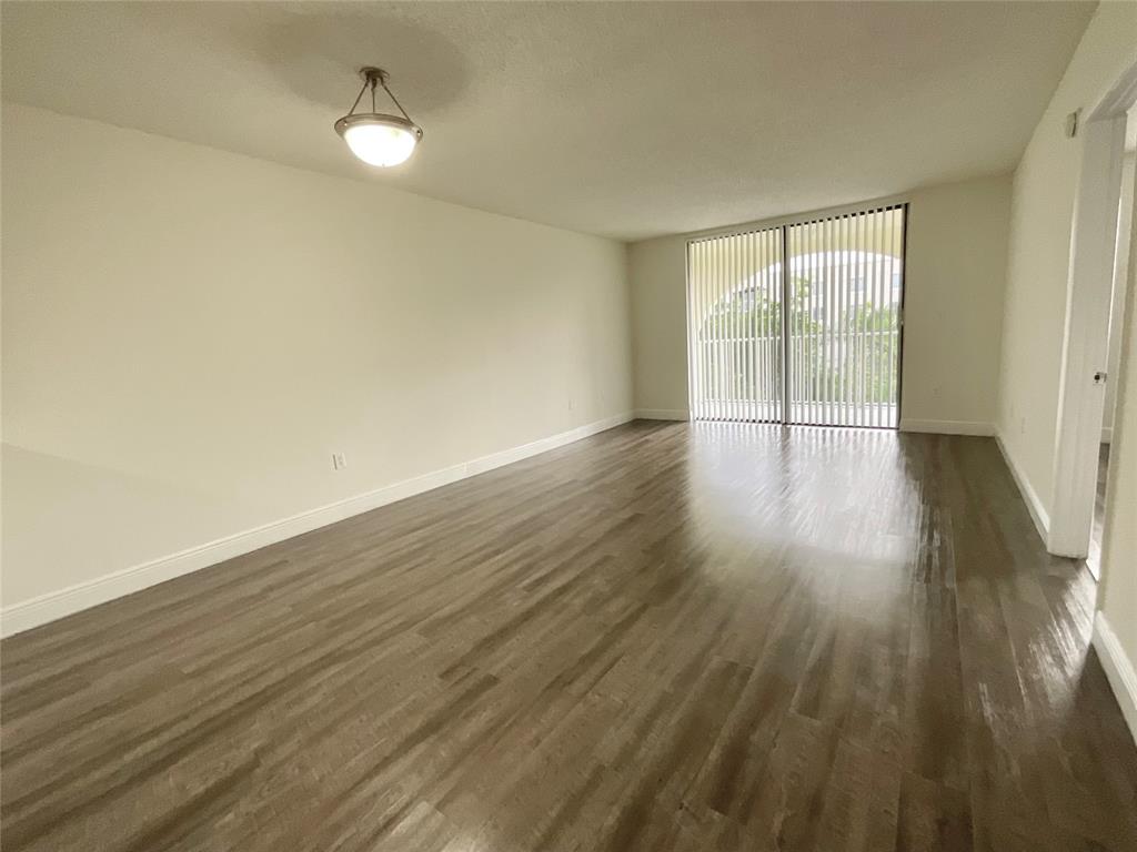 9357 Southwest 77th Avenue, Unit 25245 Miami, FL 33156 - Photo 2 of 20 wooden floor in an empty room with a window