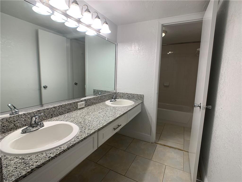 9357 Southwest 77th Avenue, Unit 25245 Miami, FL 33156 - Photo 3 of 20 a bathroom with a sink double vanity and a mirror