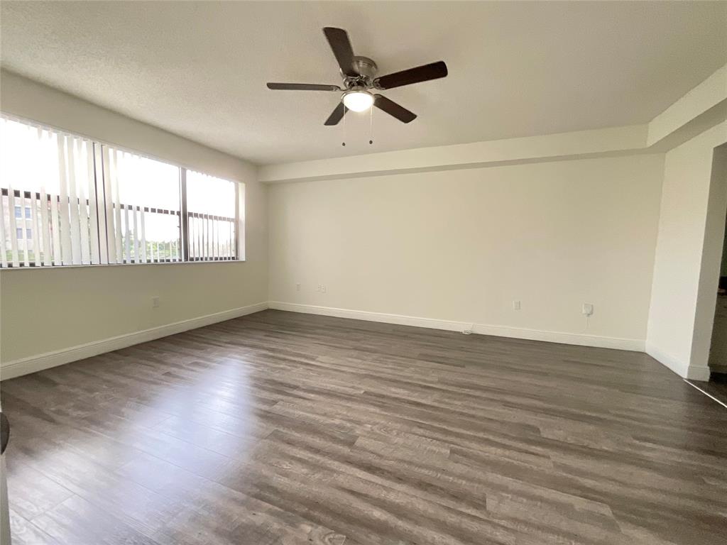 9357 Southwest 77th Avenue, Unit 25245 Miami, FL 33156 - Photo 4 of 20 an empty room with wooden floor and windows