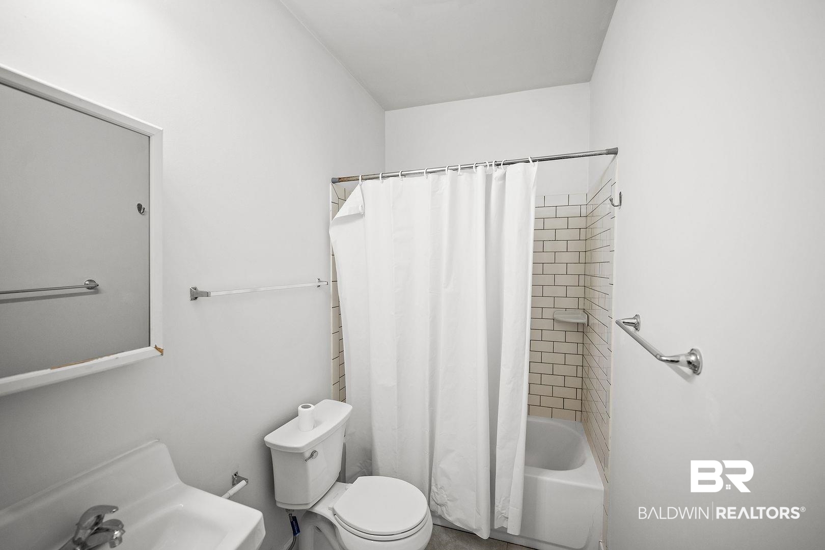 635 East Azalea Avenue Foley, AL 36535 - Photo 11 of 18 Bathroom featuring a subway tile shower surround, built-in tub, wall-mounted sink, and a mirrored medicine cabinet