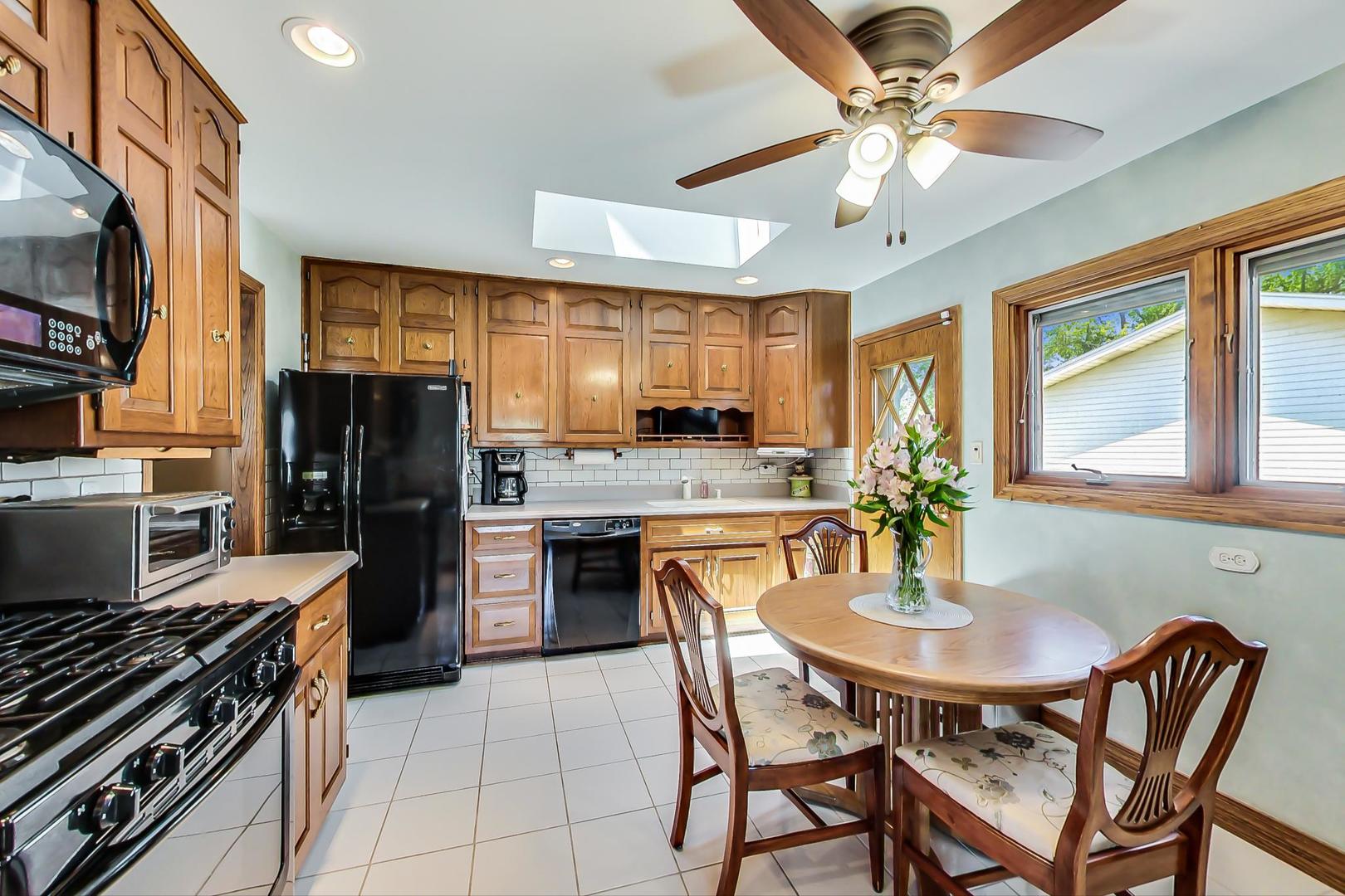 1715 Fremont Road Hoffman Estates, IL 60169 - Photo 12 of 59 a kitchen with stainless steel appliances granite countertop a stove a refrigerator a sink a dining table and chairs