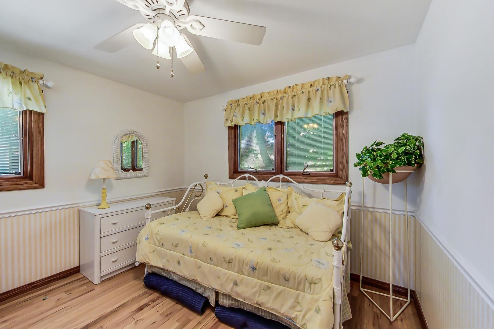 1715 Fremont Road Hoffman Estates, IL 60169 - Photo 21 of 59 a bedroom with a large bed and a chandelier