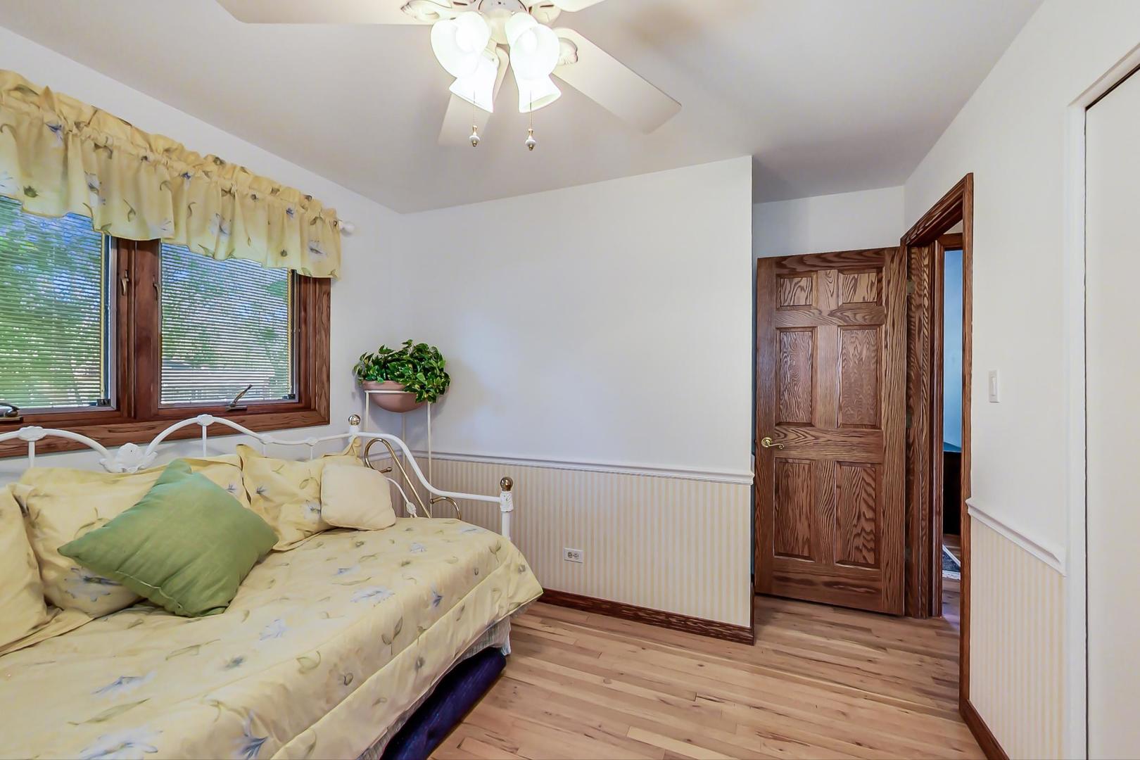 1715 Fremont Road Hoffman Estates, IL 60169 - Photo 23 of 59 a bedroom with a bed and a chandelier