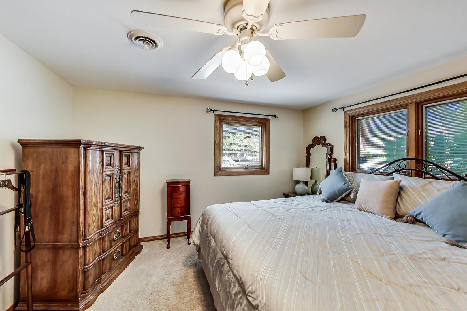 1715 Fremont Road Hoffman Estates, IL 60169 - Photo 31 of 59 a bedroom with a large bed and a chandelier