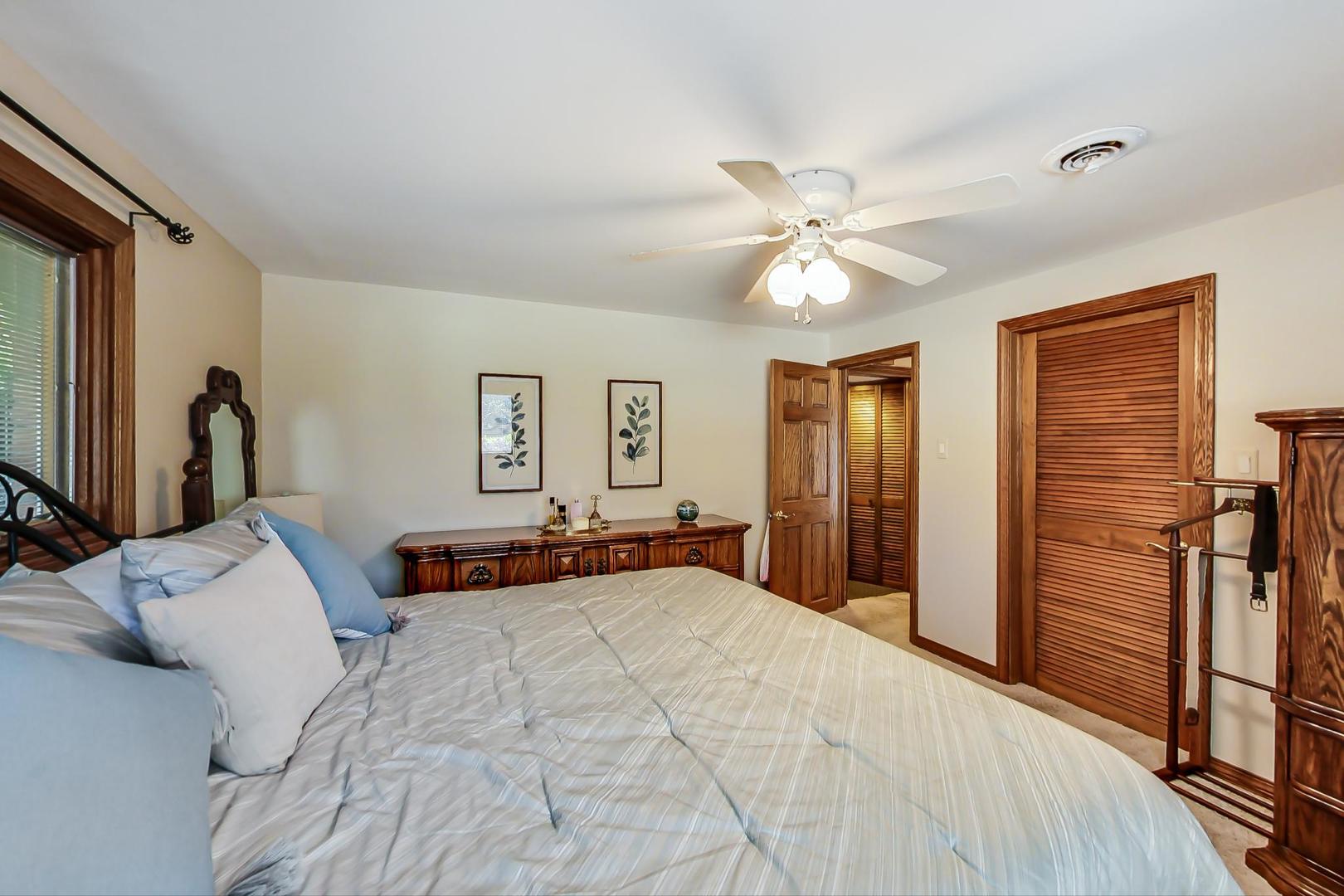 1715 Fremont Road Hoffman Estates, IL 60169 - Photo 32 of 59 a bedroom with a large bed and a chandelier